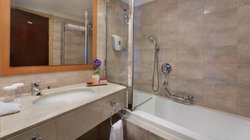 海法Crowne Plaza Haifa, an IHG Hotel的带浴缸、水槽和淋浴的浴室
