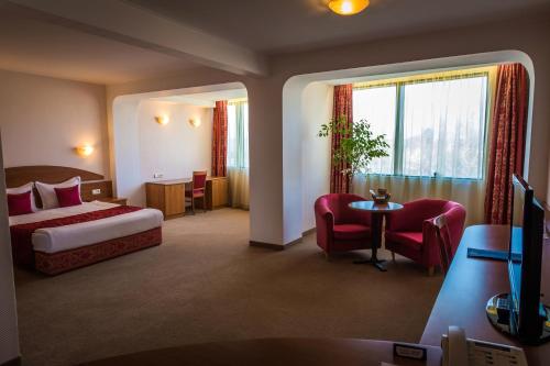 塞夫利耶沃塞弗利夫广场酒店的酒店客房带一张床、一张桌子和椅子