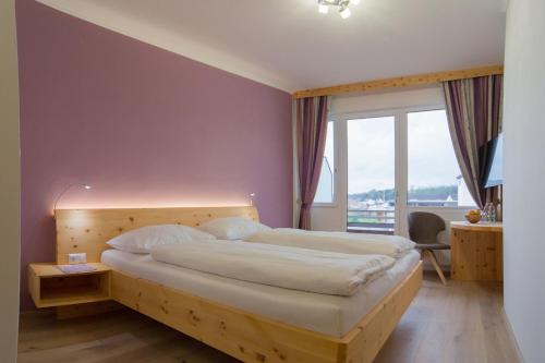 格赖因加斯霍夫足尔特劳伯酒店的一间卧室设有一张大床和一个大窗户