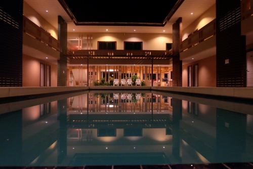 安帕瓦安帕瓦君提玛酒店的一座带房子的建筑中的游泳池