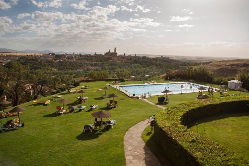 塞哥维亚塞戈维亚旅馆的田野里的一个游泳池,周围的人坐在里面