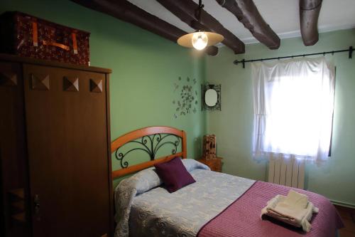 Alcalá de MoncayoCasa Rural La Tejada的一间卧室设有一张床和一个窗口