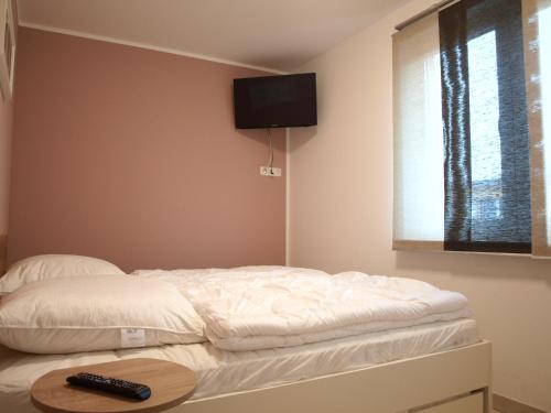 格拉尔-米里茨Ferienwohnung Graal Müritz im Igelring的一间卧室设有两张床,墙上配有电视。