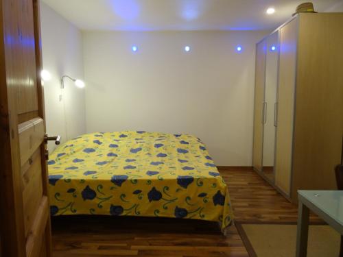 维利尔斯Vire de Vie的一间卧室配有一张黄色和蓝色毯子的床