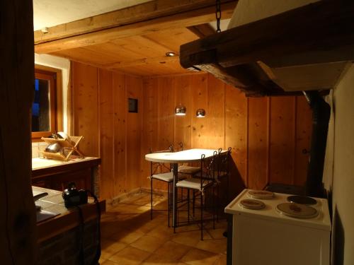 维利尔斯Vire de Vie的厨房设有木墙、桌子和炉灶。