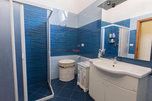 托雷圣乔万尼乌Villetta Angela的蓝色的浴室设有水槽和淋浴