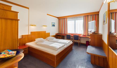 维也纳Vienna Sporthotel的配有一张床和一张书桌的酒店客房