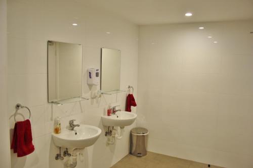 珀斯Quokka Backpackers Hostel Perth - note - Valid passport required to check in的白色的浴室设有两个盥洗盆和镜子