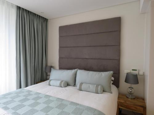 开普敦海滨地区凯尔莫尔A202公寓的卧室配有一张带两个枕头的大白色床
