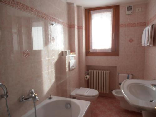布勒伊-切尔维尼亚Hotel Lyskamm的带浴缸、卫生间和盥洗盆的浴室