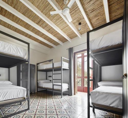 马略卡岛帕尔马The Boc Hostels - Palma的一间卧室设有两张双层床和天花板