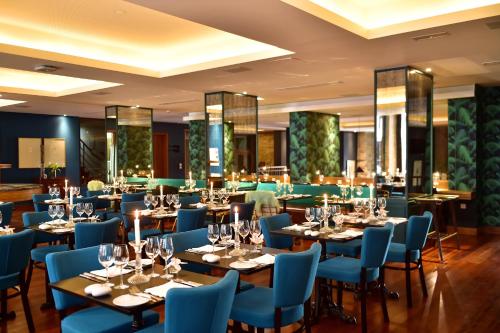 波尔图波尔图世界遗产佩斯塔纳复古酒店的一间配备有桌子和蓝色椅子的用餐室