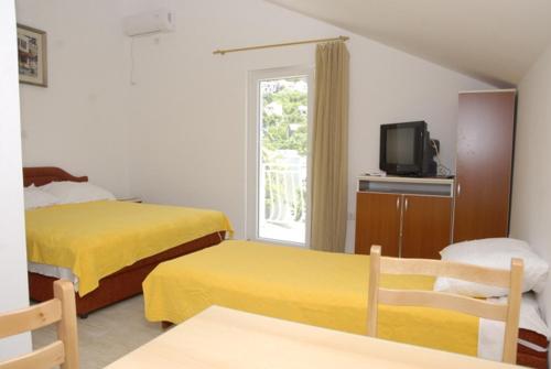 蒂瓦特Apartments Dosljak的酒店客房设有两张床和电视。