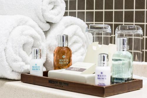 伦敦蒙塔古广场酒店的浴室提供2瓶肥皂和毛巾