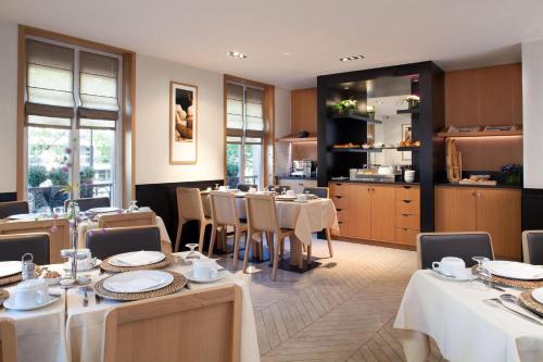 巴黎玛索香榭丽舍酒店的一间带桌椅的餐厅和一间厨房