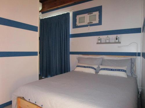 葛伦坦马勒Ittiturismo Il Vecchio e il Mare的一间卧室配有一张蓝色和白色条纹的床