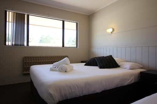 阿达米纳比雪山度假酒店和功能中心汽车旅馆的一间卧室配有一张大床和毛巾