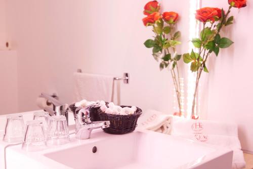 努美阿中心酒店的浴室水槽,上面装有一篮鲜花