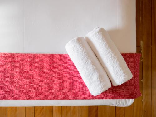 霍巴特蒙塔丘特精品旅舍的红色垫子上两条白色毛巾