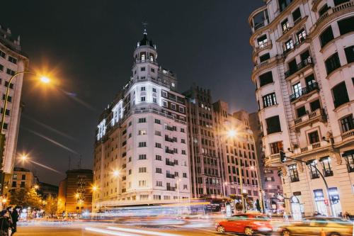 马德里马德里迪尔酒店的一座大建筑,在城市街道上,晚上有塔楼