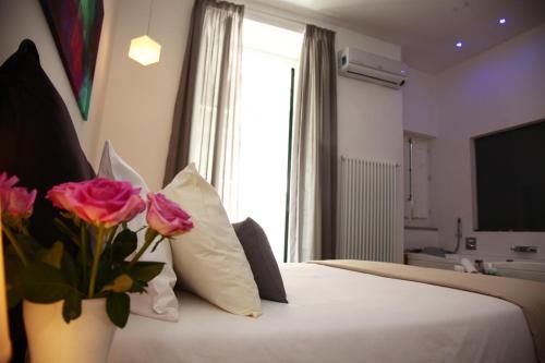 巴勒莫马西莫住宿加早餐旅馆的酒店客房的床铺上装饰有粉红色玫瑰花