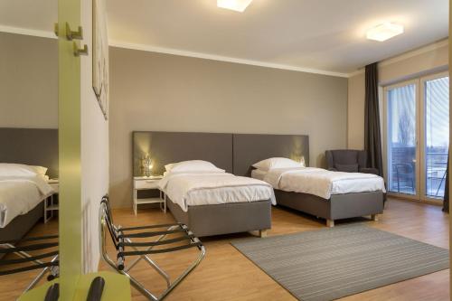新伊钦Apartmány Abacie的一间卧室配有两张床和椅子
