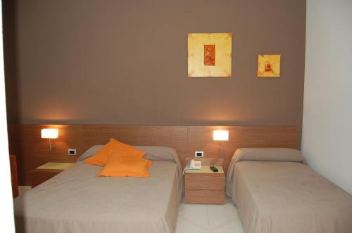 圣巴巴拉迭戈酒店的配有两盏灯的小房间内的两张床
