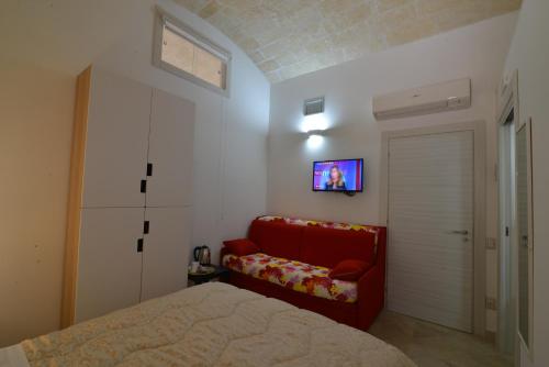 马泰拉Il Nespolo Matera的卧室配有红色沙发,墙上配有电视