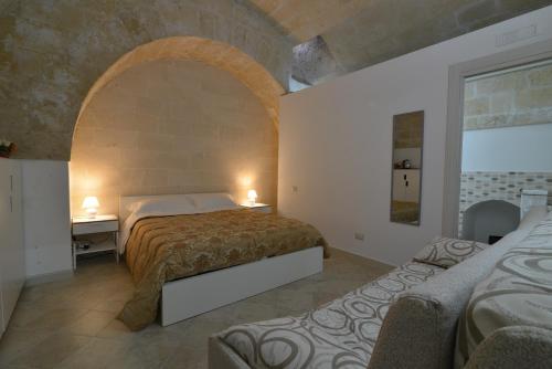 马泰拉Il Nespolo Matera的一间带两张床的卧室和一个拱门