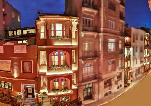 伊斯坦布尔Faik Pasha Hotels Special Category Beyoglu Istanbul的一群高大的建筑,上面有灯