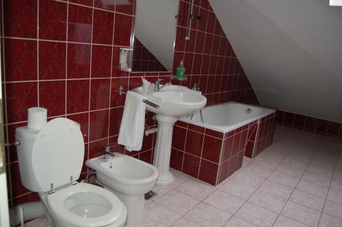 德瓦麦斯特罗汽车旅馆的红色瓷砖浴室设有卫生间和水槽