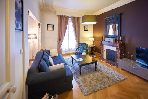 勒芒Appartements Plantagenet - Le 33的客厅设有蓝色的沙发和壁炉