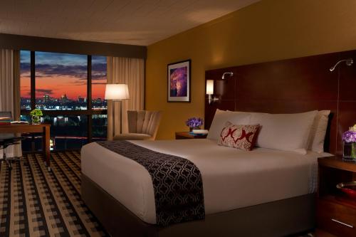 奇克托瓦加M Hotel Buffalo的配有一张床、一张书桌和一扇窗户的酒店客房