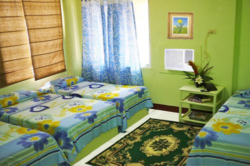 宿务彭斯内太平洋酒店的一间卧室配有两张单人床和一张地毯。