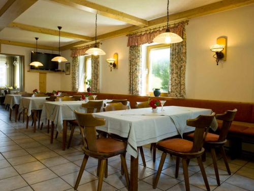 格拉弗瑙卢森布里克旅馆的一间设有白色桌椅的用餐室