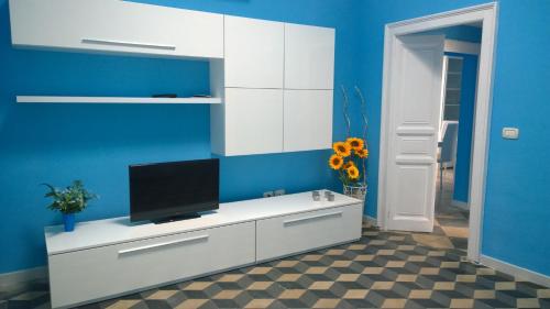 奥斯图尼I Cieli Di Ostuni的一间客厅,在白色的橱柜上配有电视
