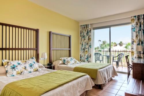 萨洛PortAventura Hotel Caribe - Includes PortAventura Park Tickets的酒店客房设有两张床和一个阳台。