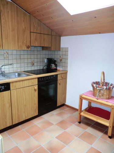 施瓦尔茨湖Sonja的厨房配有木制橱柜和黑色洗碗机。