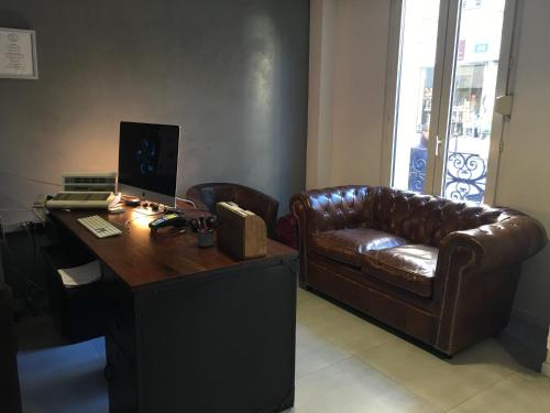 巴黎地匹酒店的办公室设有真皮沙发和带电脑的书桌