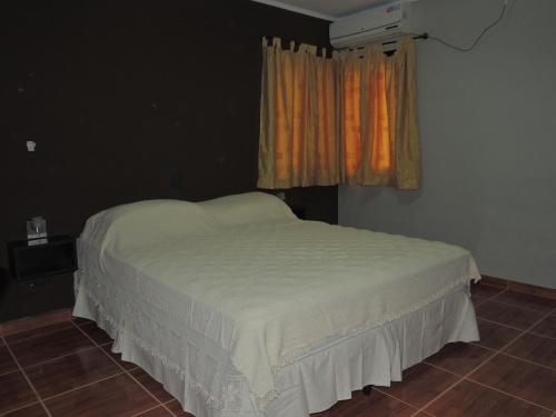 科隆Apartamento Brisas del Golf的窗户和白色床罩的房间里一张床位