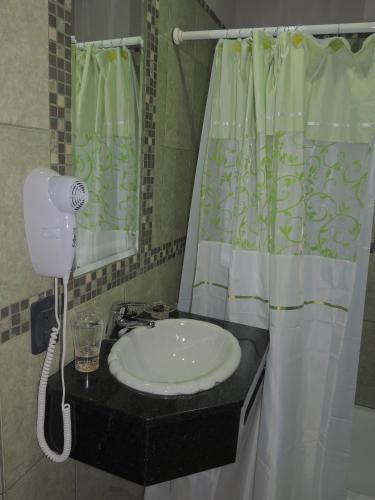 科隆Apartamento Brisas del Golf的一间带水槽和淋浴帘的浴室