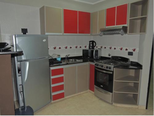 科隆Apartamento Brisas del Golf的厨房配有红色和黄色的橱柜和冰箱