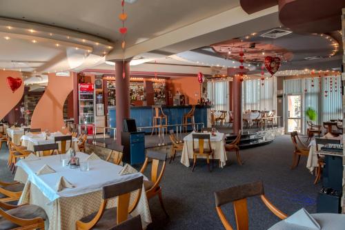 扬博尔Hotel Kapri的一间带桌椅的用餐室和一间酒吧
