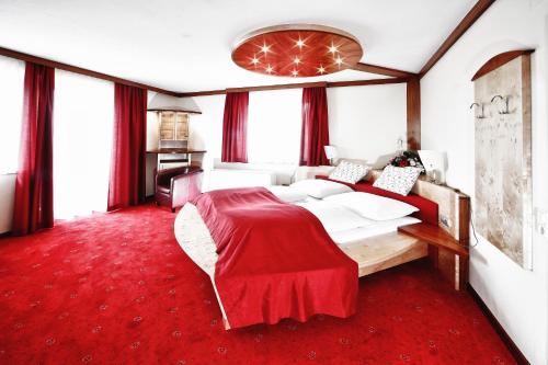 Eberstein加斯特霍夫古特曼酒店的一间卧室配有一张大床,铺有红地毯