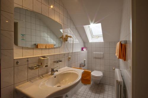 巴登韦勒纽恩菲尔斯酒店的一间带水槽、卫生间和镜子的浴室
