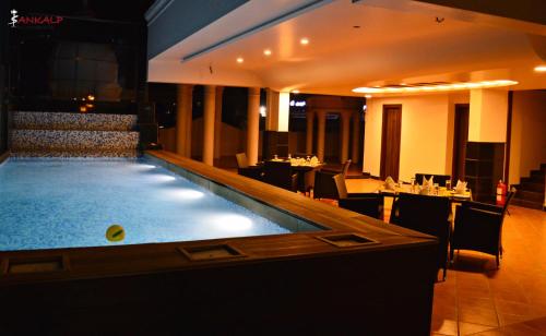 迈索尔Sepoy Grande Mysore的一个带酒吧和桌子的餐厅内的游泳池