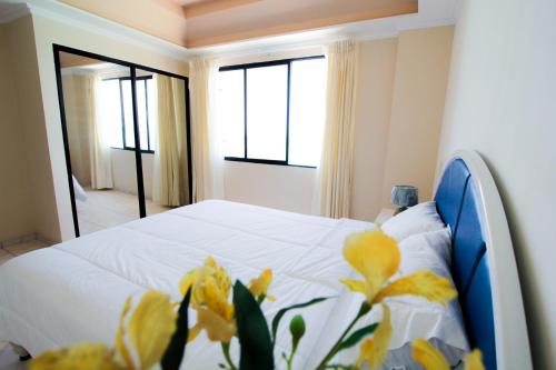 萨利纳斯蓝湾酒店的一间卧室,床上有黄色的鲜花