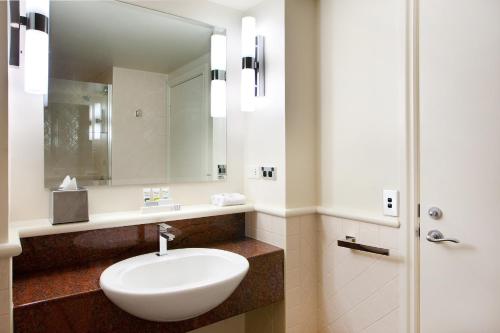 黄金海岸黄金海岸美居度假酒店的浴室设有白色水槽和镜子