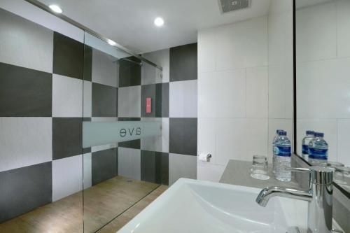 班贾尔马辛favehotel Ahmad Yani Banjarmasin的浴室设有水槽和带水瓶的淋浴。