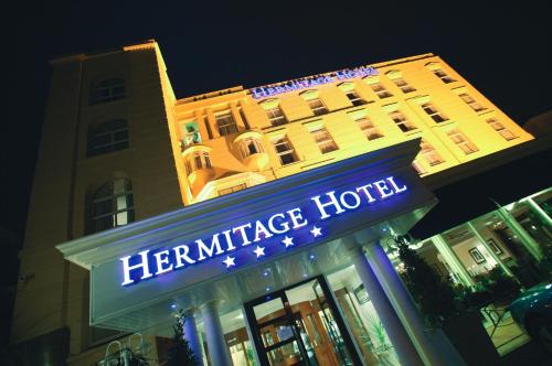伯恩茅斯The Hermitage Hotel - OCEANA COLLECTION的夜间在大楼前的酒店标志